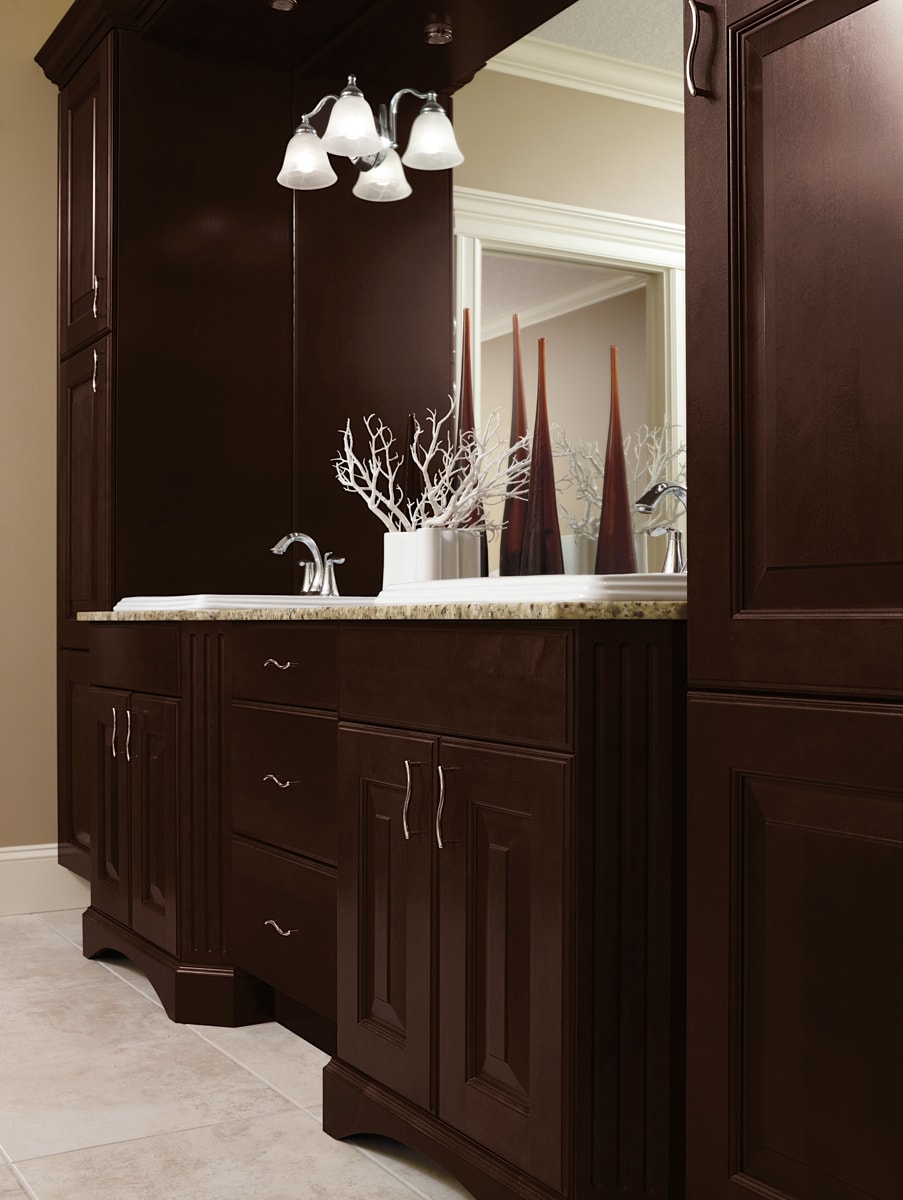 Dark brown bathroom vanity with numerous cabinets and drawers.