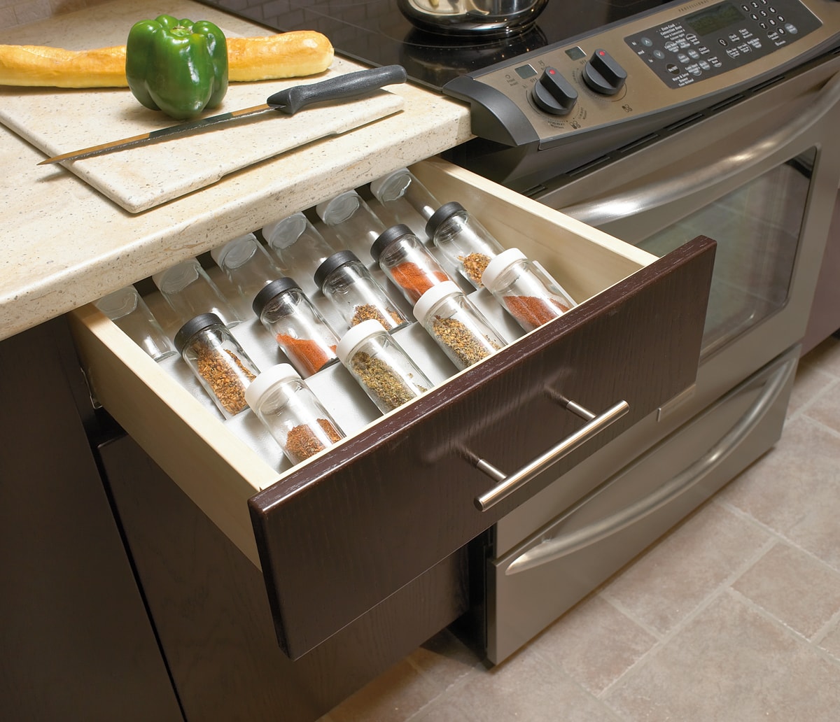 Open brown cabinet drawer with a 3-tier spice drawer.